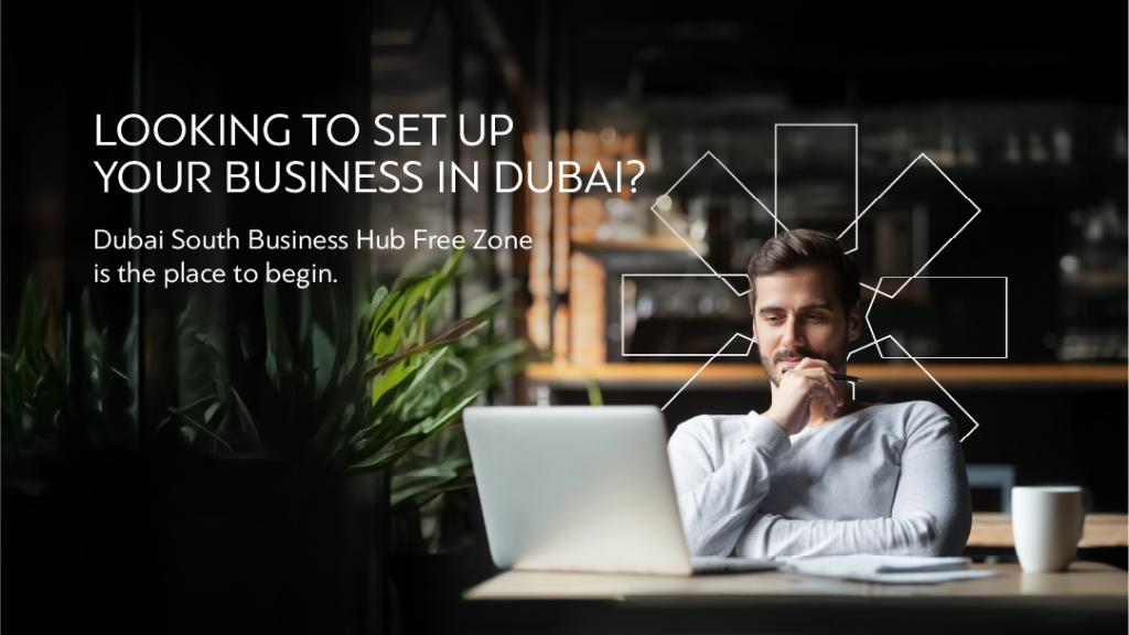 Man looking at laptop, considering setting up business in Dubai South Free Zone. "Looking to set up your business in Dubai?