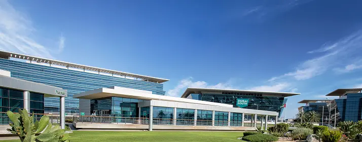 Dubai South buildings with clear blue sky. Dubai South sign visible. Modern architecture in Dubai.