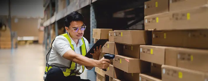 Warehouse worker scanning boxes in a warehouse. Get start your business in Dubai.